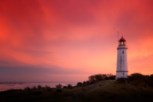 Leuchtturm Dornbusch auf Hiddensee mit eingeschaltetem Leuchtfeuer vor dramatischem Himmel bei Sonnenuntergang Leuchtturm Dornbusch auf Hiddensee mit eingeschaltetem Leuchtfeuer vor dramatischem Himmel bei Sonnenuntergang